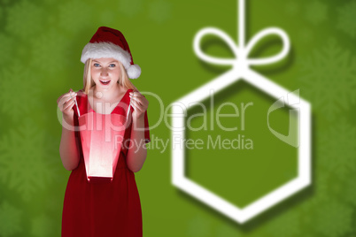 Composite image of festive blonde opening a gift bag