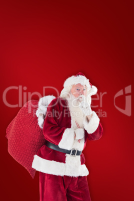 Composite image of santa asking for quiet with bag