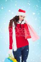Composite image of happy brunette in winter wear holding shoppin