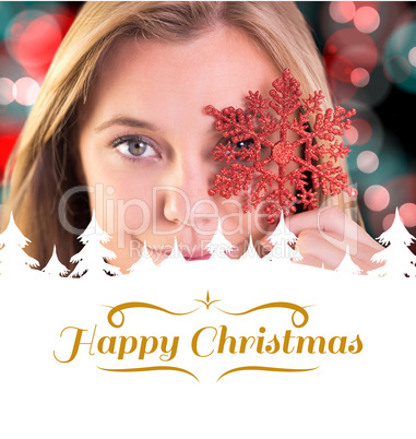 Composite image of festive blonde holding a snowflake