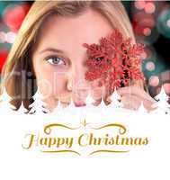 Composite image of festive blonde holding a snowflake