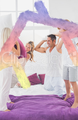 Composite image of family having fun with pillows