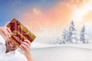 Composite image of festive man holding christmas gift