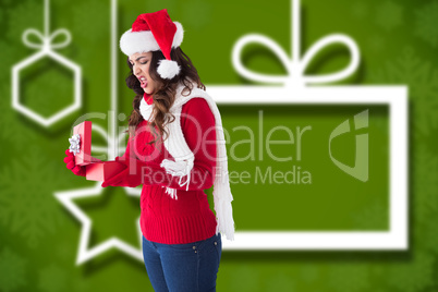 Composite image of disgusted brunette opening christmas gift