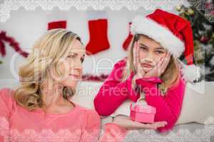 Composite image of festive mother and daughter with gift