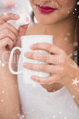 Composite image of close up of woman holding mug and marshmallow