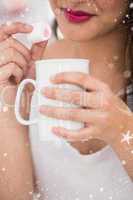 Composite image of close up of woman holding mug and marshmallow