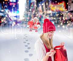 Composite image of happy blonde opening gift bag