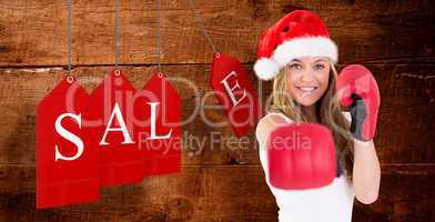 Composite image of festive blonde punching with boxing gloves