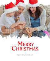 Composite image of happy parents with thir opening crackers toge