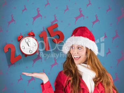 Composite image of festive redhead presenting with hand