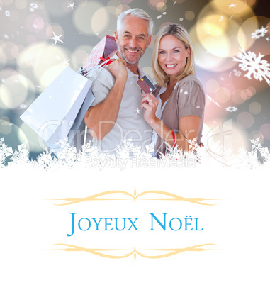 Composite image of happy couple with shopping bags and credit ca