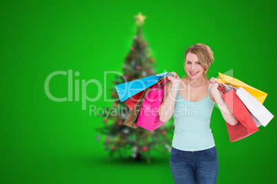 Composite image of cheerful blonde woman holding shopping bags