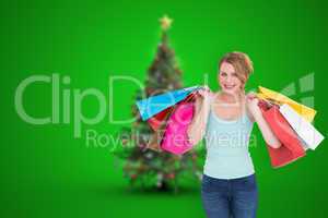 Composite image of cheerful blonde woman holding shopping bags