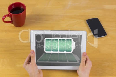 Composite image of businesswoman using tablet at desk