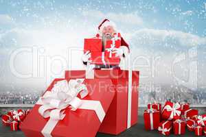 Composite image of santa standing in large gift