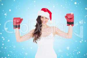 Composite image of festive brunette in boxing gloves with arms r