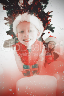 Composite image of festive little siblings smiling at camera hol