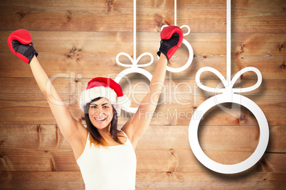 Composite image of festive brunette in boxing gloves cheering