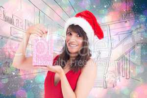 Composite image of festive brunette holding a gift bag