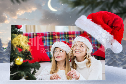 Composite image of festive mother and daughter decorating christ