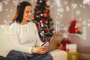 Composite image of pretty brunette shopping online at christmas