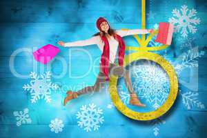 Composite image of smiling brunette jumping with gifts bags