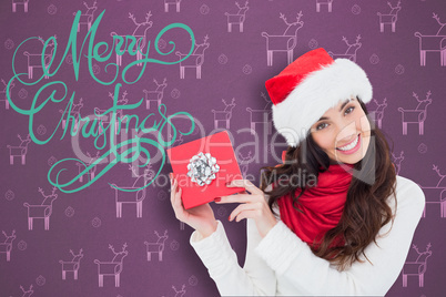 Composite image of joyful brunette presenting christmas gift