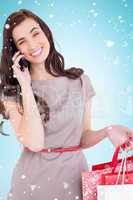 Composite image of smiling brunette with shopping bags on the ph