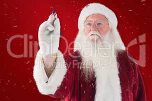 Composite image of santa writes something with a pen