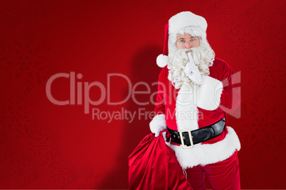 Composite image of santa holding his sack and keeping a secret