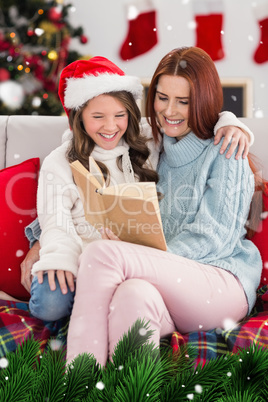 Composite image of festive mother and daughter reading on the couch
