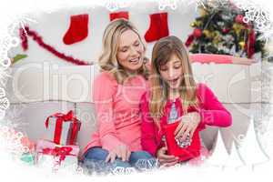 Composite image of little girl opening a gift at christmas with