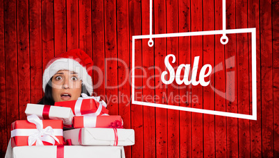 Composite image of shocked woman with christmas presents