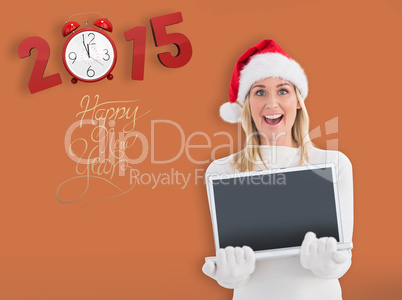 Composite image of festive blonde showing a laptop