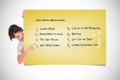 Composite image of cute guy pointing at a list