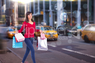 Composite image of excited brunette with shopping bags