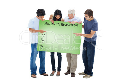Composite image of people holding and watching a big sign