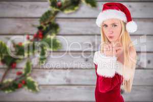 Composite image of festive blonde blowing over hand