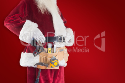 Composite image of father christmas is wearing a tool belt