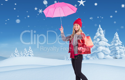 Composite image of festive blonde holding umbrella and bags