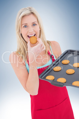 Happy blonde eating hot cookies