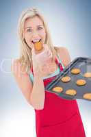 Happy blonde eating hot cookies