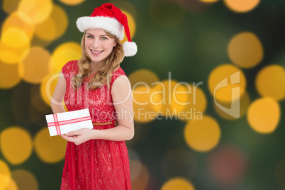 Composite image of blonde holding a christmas gift