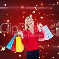 Composite image of happy blonde holding shopping bags