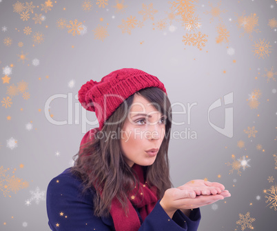 Composite image of festive brunette blowing over hands