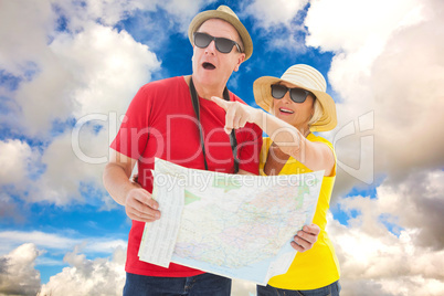 Composite image of happy tourist couple using map