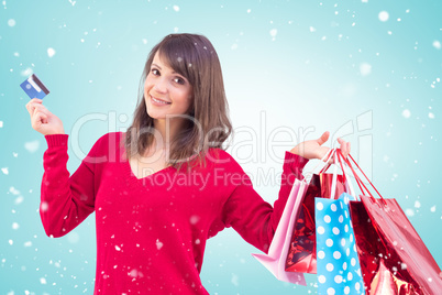 Composite image of brunette holding gift and credit card