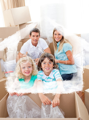 Composite image of smiling family packing boxes