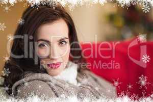 Composite image of serious brunette relaxing on the couch at chr